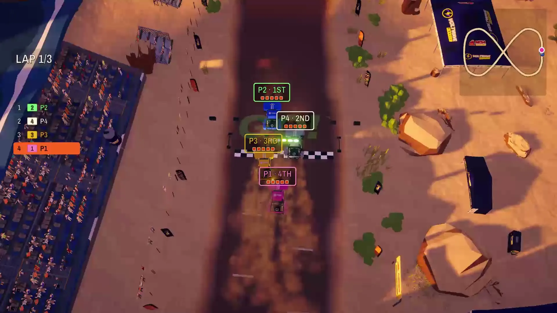 The overhead cabinet view: three trucks sliding through a desert corner lined with tire walls
